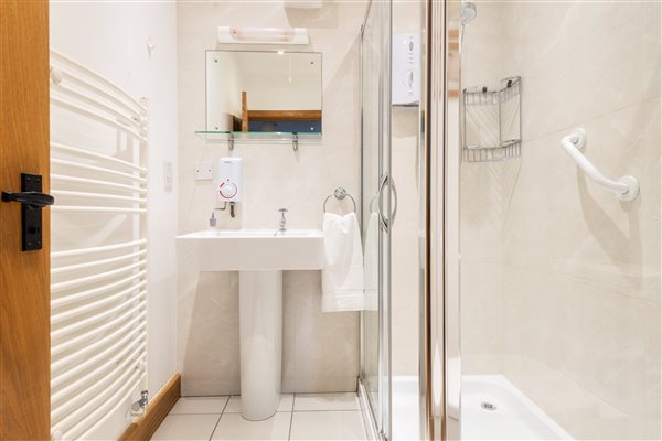 Ensuite showing shower and basin with tiled walls